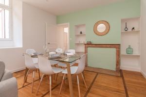 een eetkamer met een glazen tafel en witte stoelen bij Magnifique logement spacieux hyper centre in Nuits-Saint-Georges