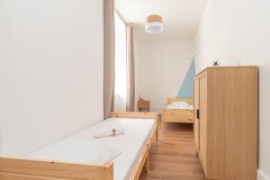 a bedroom with a bed and a wooden cabinet at Magnifique logement spacieux hyper centre in Nuits-Saint-Georges