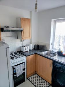 eine Küche mit Herd und Spüle in der Unterkunft Cosy&Trendy 3Bed Apt on Busy High Street With Free WiFi & Parking in Berkhamsted