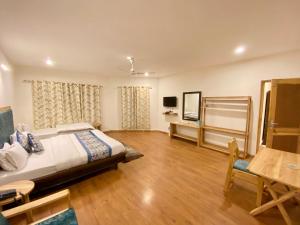 a large bedroom with a bed and a table at hotel palam hills in Leh