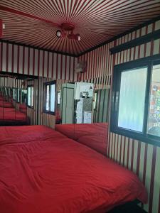 een slaapkamer met een rood bed en een raam bij Quiet and beautiful bungalow near to old Jaffa City in Mishmar Hashiv‘ah