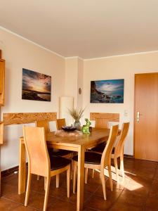 a dining room with a wooden table and chairs at Ferienhaus Dycke 6 in Zudar