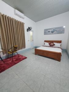 a bedroom with a bed and a desk and a chair at Tùy Anh Hostel in Mù Cang Chải