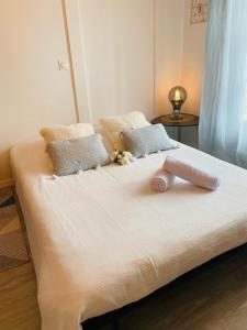 een wit bed met een handdoek erop bij L'Escale Cosy - Disneyland Paris in Serris