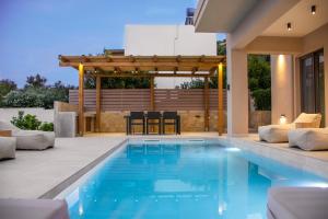 a swimming pool in a backyard with a pergola at Armour Eclectic Villa in Afráta