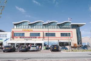 un edificio con coches estacionados frente a él en Harbour Hotel IJmuiden, en IJmuiden