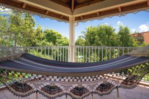a hammock on a porch with a white fence at Villa Ladouchka in Goyave