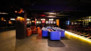 a restaurant with a bar with blue tables and chairs at Dazzling in Agra