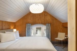 sypialnia z białym łóżkiem i krzesłem w obiekcie Krone by b-smart w mieście Bad Ragaz