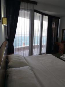 sypialnia z dużym łóżkiem i dużym oknem w obiekcie Apartman AidaLux w mieście Bijela Glavica