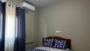 a bedroom with a bed with a pillow and a window at Magistral apparts in Yaoundé