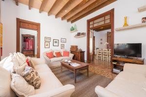a living room with white furniture and a flat screen tv at Villa Sa Verdera in Maria de la Salut