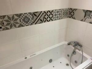 a white bath tub with a shower in a bathroom at LA CAVE in Bouleternère +6 photos