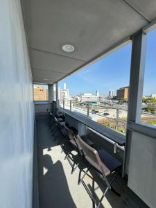 un balcone con sedie e vista sulla città di EarthVeloビル一棟貸しでフルリノベ済み各階に風呂トイレありで好立地でコスパ最高をめざしている宿です a Tokushima