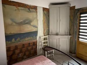 - une chambre avec un tableau mural et un lit dans l'établissement LA CAVE, à Bouleternère