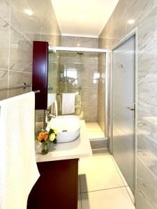 un baño con lavabo y ducha en Atlantic Pearl Guest House Rivonia, en Johannesburgo