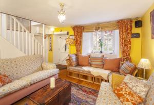 ein Wohnzimmer mit einem Sofa und einem Tisch in der Unterkunft Sausage Cottage Oakford in Oakford