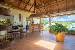 a patio with a table and chairs and plants at Villa Ladouchka in Goyave