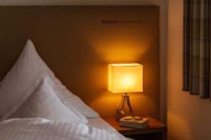 ein Schlafzimmer mit einem Bett mit einer Lampe auf einem Nachttisch in der Unterkunft Landhaus Albert Murr - Bed & Breakfast in Sankt Anton am Arlberg