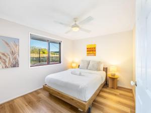 een witte slaapkamer met een bed en een raam bij Great value Stylish 2BR Granny Flat Heritage Park in Boronia Heights