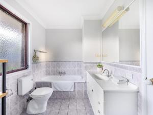 une salle de bain blanche avec toilettes et lavabo dans l'établissement Great value Stylish 2BR Granny Flat Heritage Park, à Boronia Heights