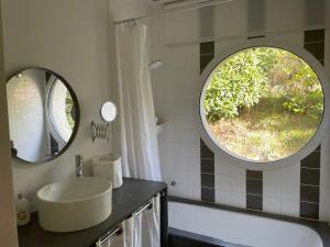 La salle de bains est pourvue d'un lavabo et d'une grande fenêtre. dans l'établissement Villa K Maison archi avec piscine 15 mn PUY du FOU, à Cholet