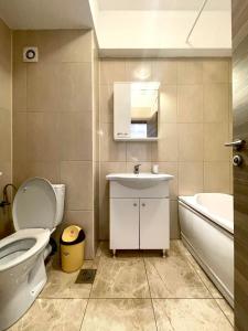 ein Badezimmer mit einem WC, einem Waschbecken und einer Badewanne in der Unterkunft Summerland Mamaia in Mamaia