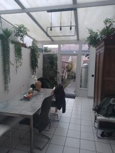 uma sala de jantar com uma mesa e algumas plantas em La petite pétillante em Reims