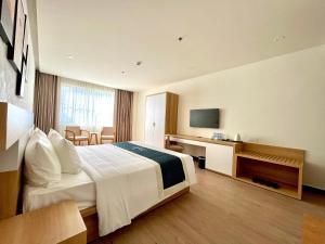 a hotel room with a bed and a television at The Hub by Hotel Academy Phu Quoc in Phú Quốc