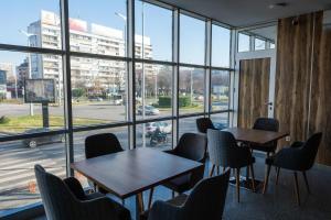HOTEL BAYKO في بلوفديف: غرفة بها طاولات وكراسي ونافذة كبيرة