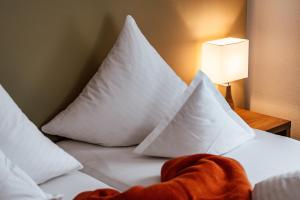 einen Haufen Kissen auf einem Bett in einem Zimmer in der Unterkunft Landhaus Albert Murr - Bed & Breakfast in Sankt Anton am Arlberg
