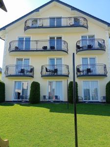 een groot wit gebouw met balkons erop bij Villa Over Lake in Mielno