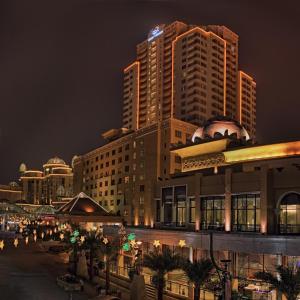 Resort Suites at Bandar Sunway في بيتالينغ جايا: أفق المدينة في الليل مع المباني الطويلة