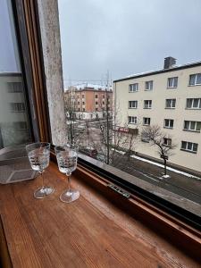 dos copas de vino sentadas en el alféizar de la ventana en Central Apartment, en Jelgava