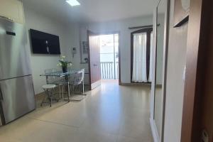 een kamer met een keuken met een tafel en een koelkast bij Apartamento Conil Centro y Playa, San Sebastian in Conil de la Frontera