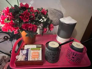 une table rose avec des fleurs, deux bougies et un vase dans l'établissement Maison d'Hôtes L'Escale Du Loup Blanc, à Maringes