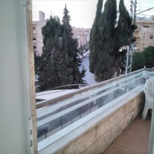 a balcony with a view of a street and trees at Jordan home in Irbid