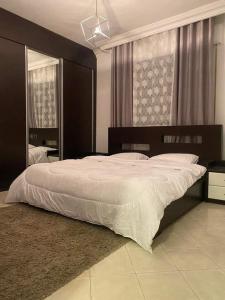 1 dormitorio con 1 cama grande y espejo grande en Jordan home, en Irbid