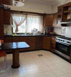 a kitchen with wooden cabinets and a stove top oven at Jordan home in Irbid