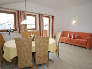 ウダーンスにあるSpacious Apartment in Uderns near Ski Areaのリビングルーム(テーブル、椅子、ソファ付)