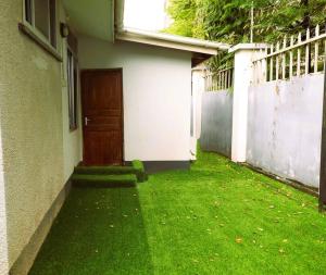 a door on the side of a house with green grass at Tranquil Masaki Stylish Studio in Dar es Salaam