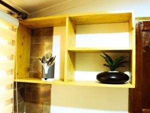 a wooden shelf with a potted plant in a bathroom at Tranquil Masaki Stylish Studio in Dar es Salaam