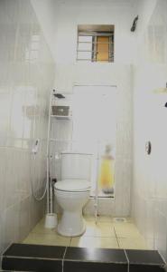 W pokoju znajduje się łazienka z białą toaletą. w obiekcie Tranquil Masaki Stylish Studio w mieście Dar es Salaam