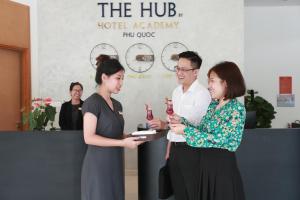 a group of three people standing around a table at The Hub by Hotel Academy Phu Quoc in Phú Quốc