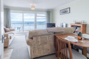 a living room with a couch and a table at 36 Beach Court - 1 Bed Apartment - Saundersfoot in Saundersfoot