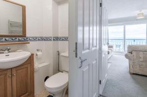 a bathroom with a toilet and a sink and a mirror at 36 Beach Court - 1 Bed Apartment - Saundersfoot in Saundersfoot +33 photos
