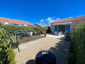 a backyard with a patio with chairs and tables at maison vue sur mer dans les dunes avec acces direct aux plages in Bretignolles-sur-Mer