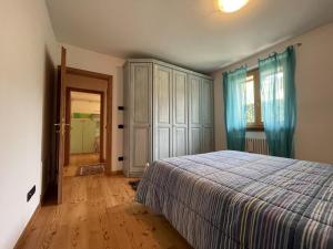 um quarto com uma cama e um armário grande em 094 Trilocale, pinzolo em Pinzolo