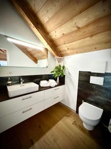 a bathroom with a toilet and a sink at Hotel Des Alpes in Inden
