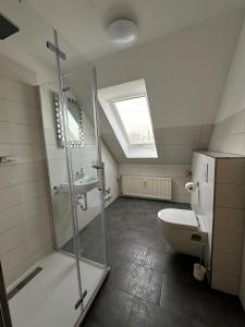 uma casa de banho com um chuveiro, um WC e uma janela. em Harzglück em Ballenstedt